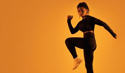 Woman in workout attire with orange background