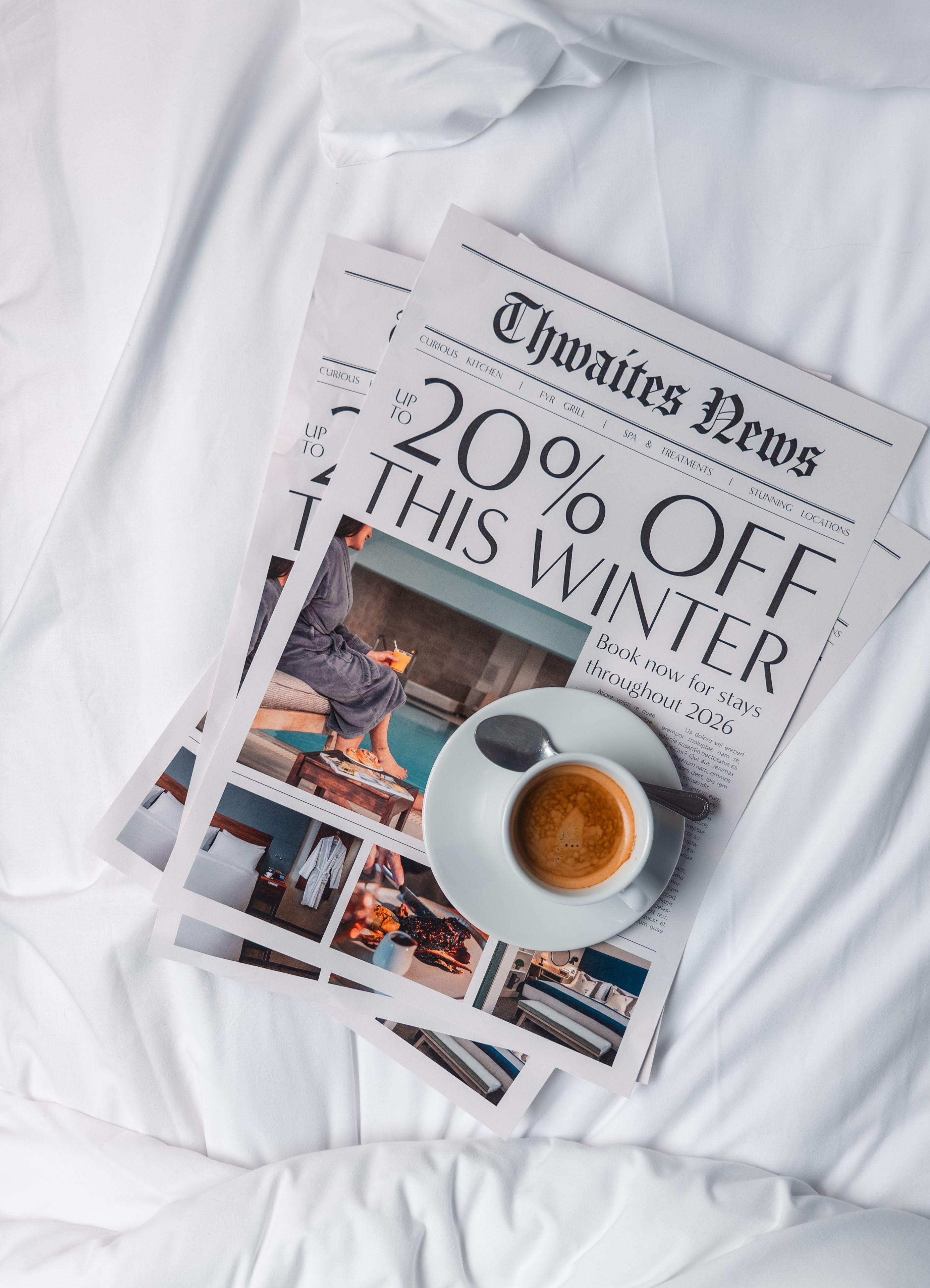 Magazine and coffee on hotel bed with the headline "Up to 20% off this winter"