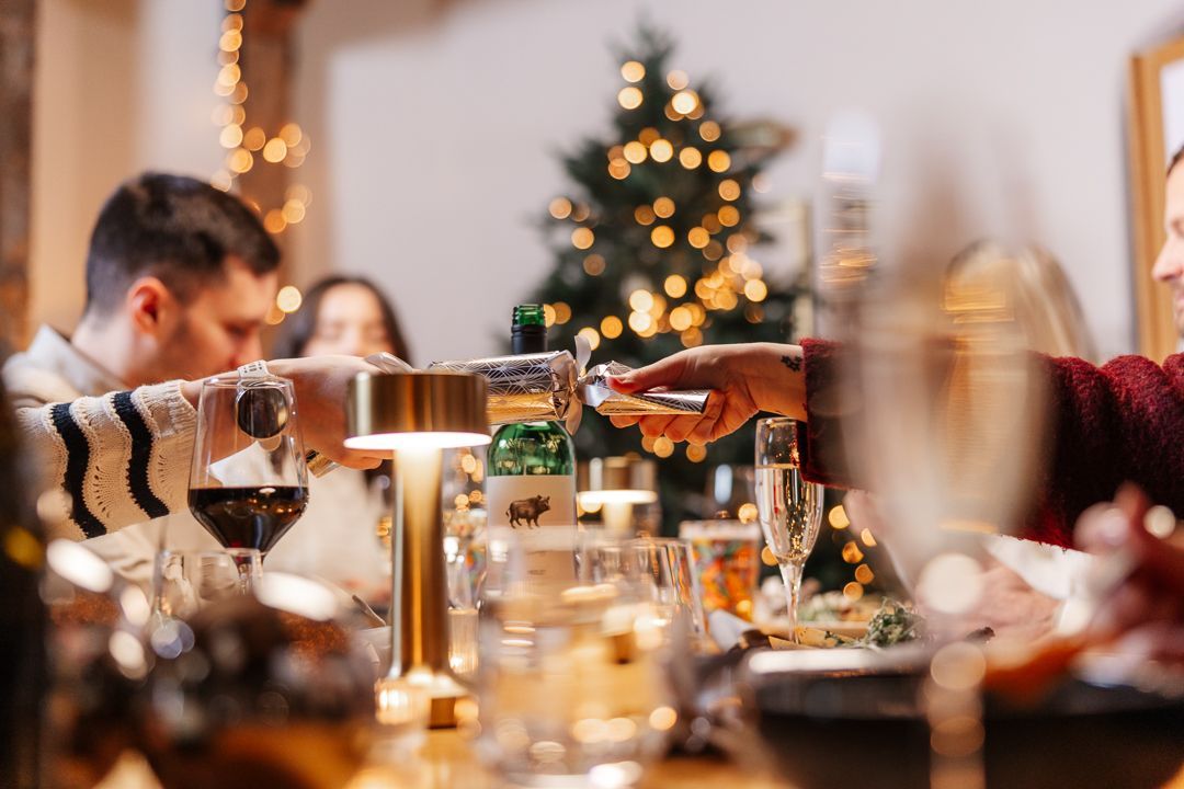 Christmas dining group pulling cracker